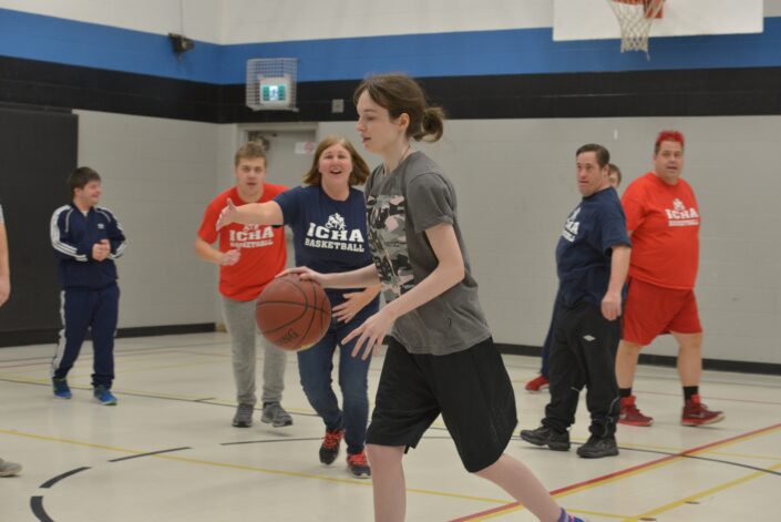 ICHA Basketball participants dribble the ball on the court