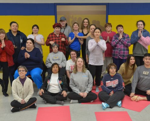"Coco" Nicole Daignault stands with her yoga program participants
